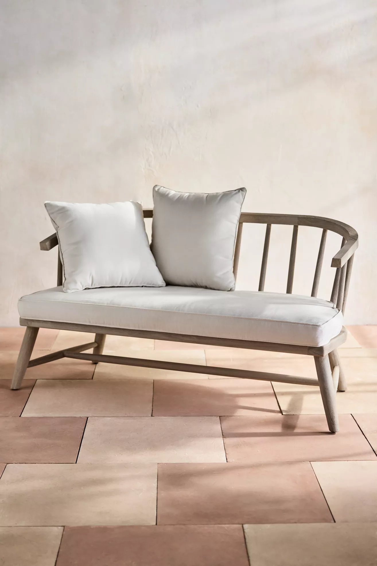 Teak outdoor two-seat sofa with two white cushions
