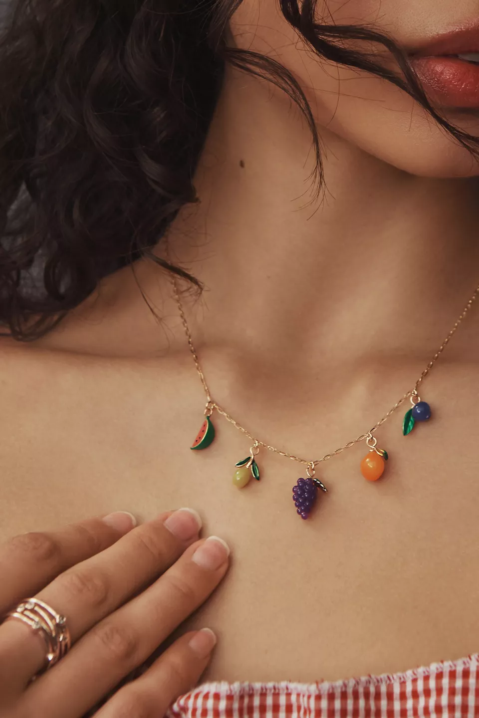 a woman wearing a fruit charm necklace