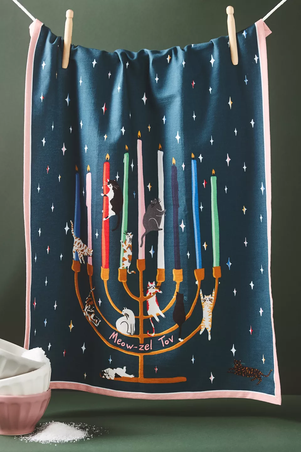 A blue dish towel with a menorah and cats on it