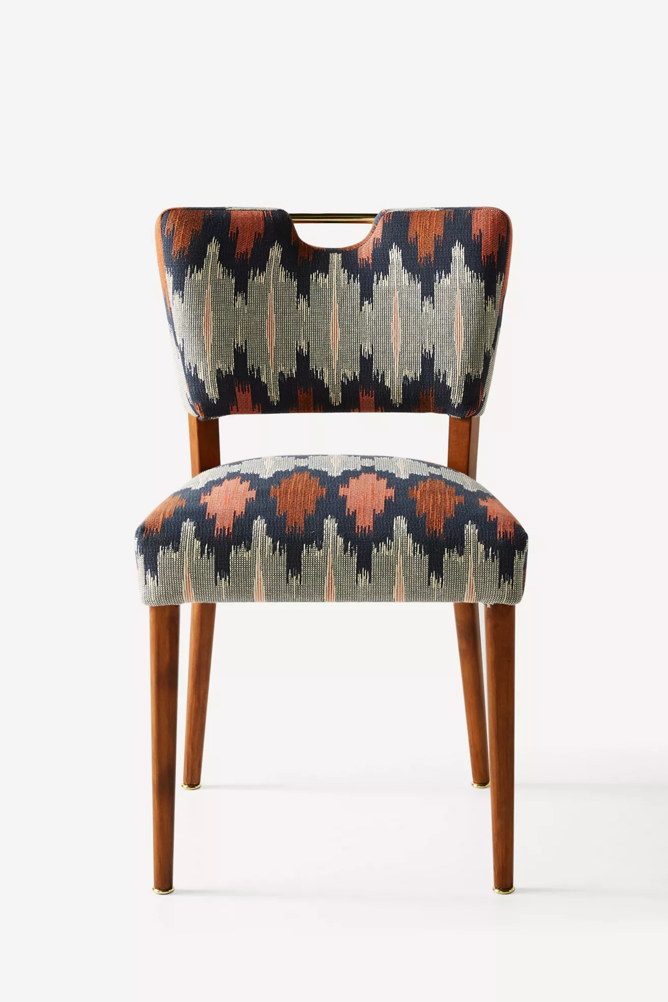 Close-up of Wyatt dining chair upholstered fabric with teal, rust, and beige ikat pattern