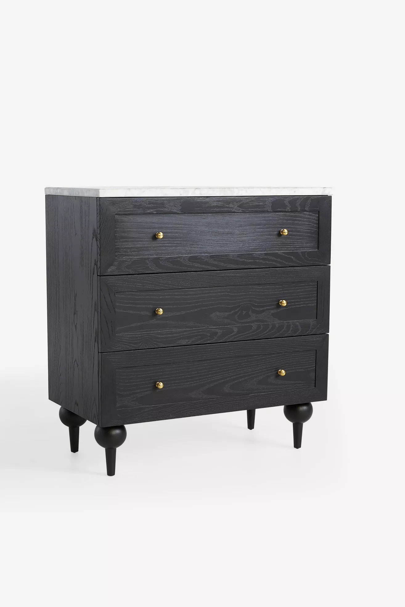 Close-up of black dresser drawers with gold knobs