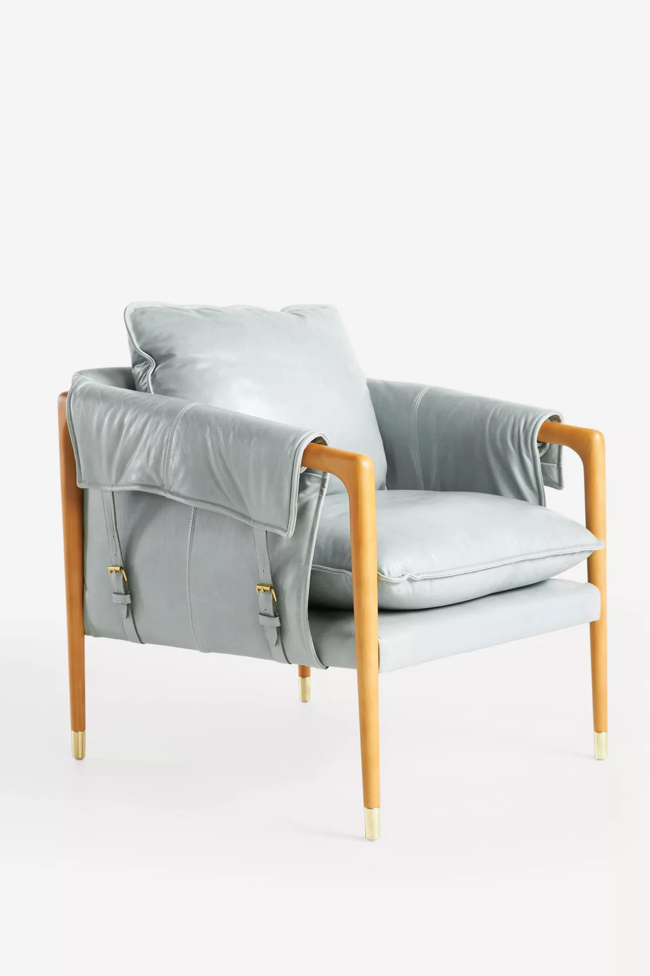 Side view of Havana leather armchair in light gray with wooden legs and strapped back