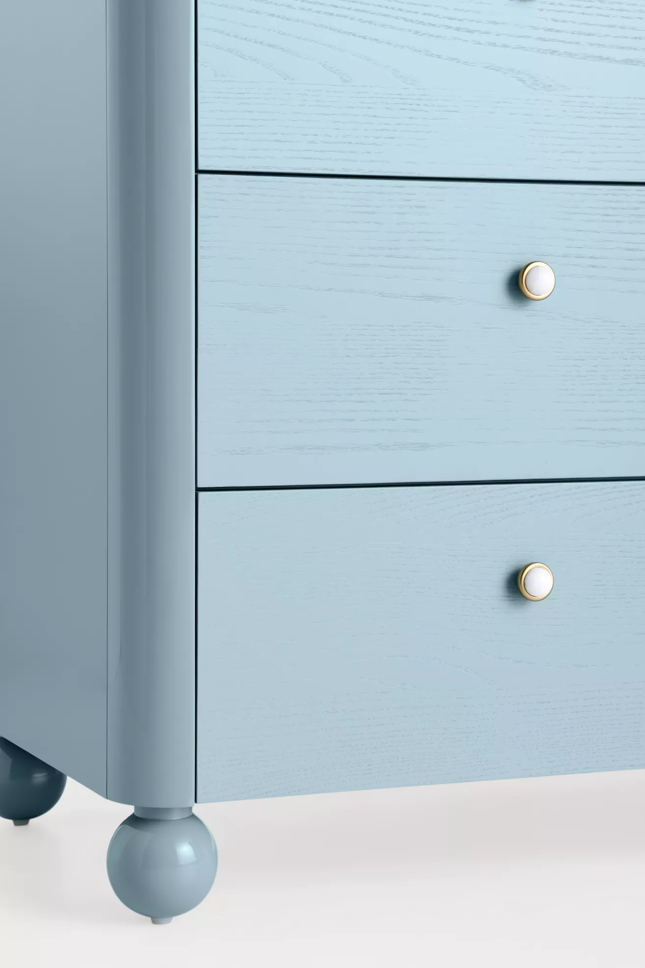 Close-up of dresser drawer fronts showing wood grain and knobs