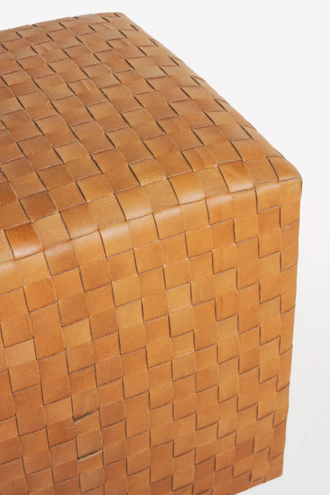 close-up corner of woven leather ottoman