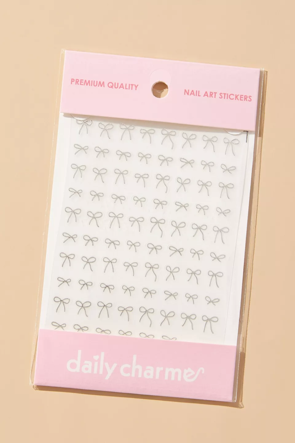 A package of silver bow nail stickers with pink labels