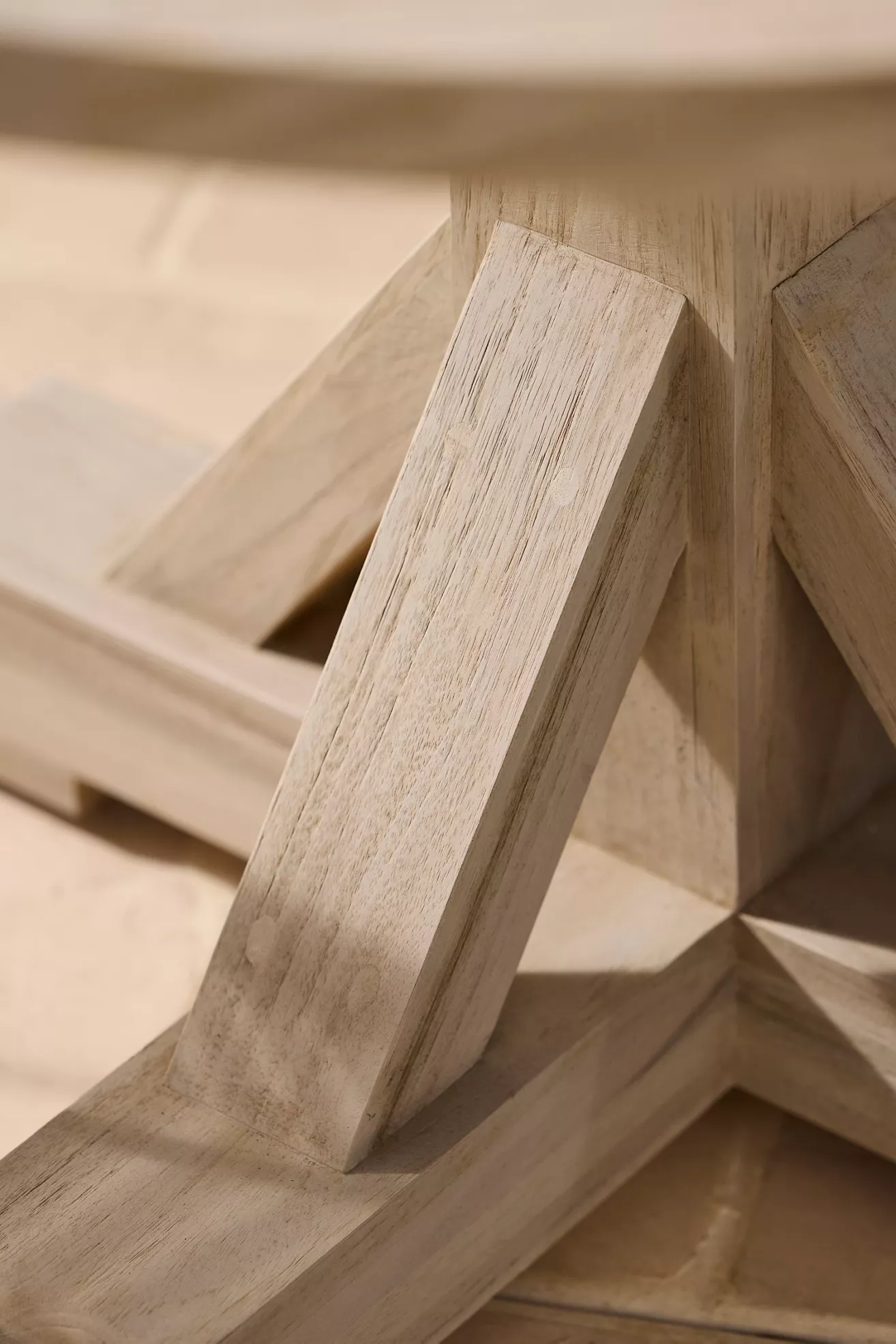 Crossed pedestal legs detail on teak dining table