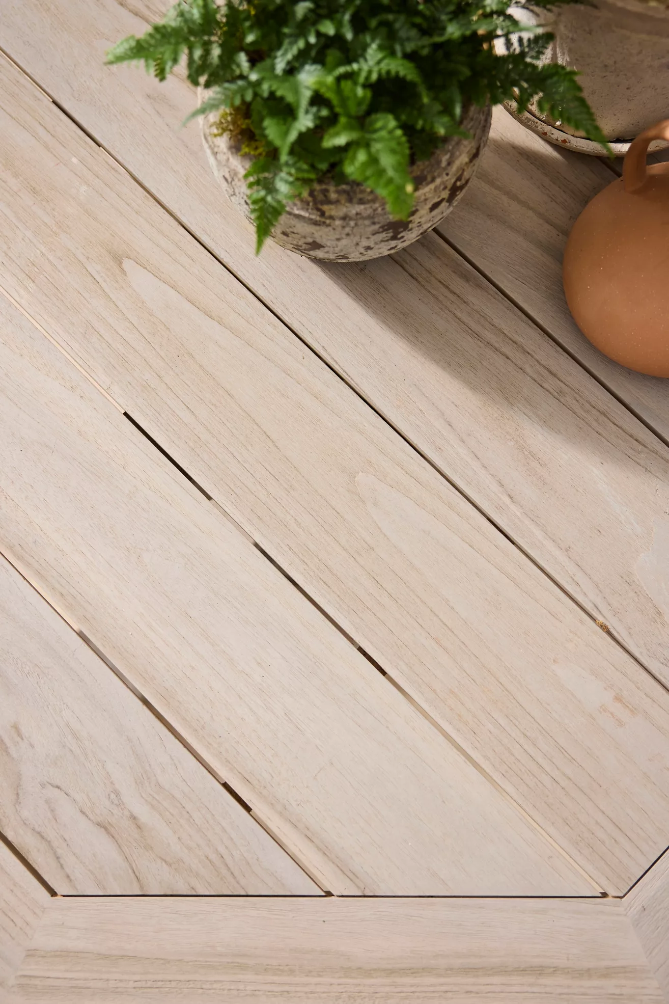 Wood tabletop surface and seam detail on teak dining table