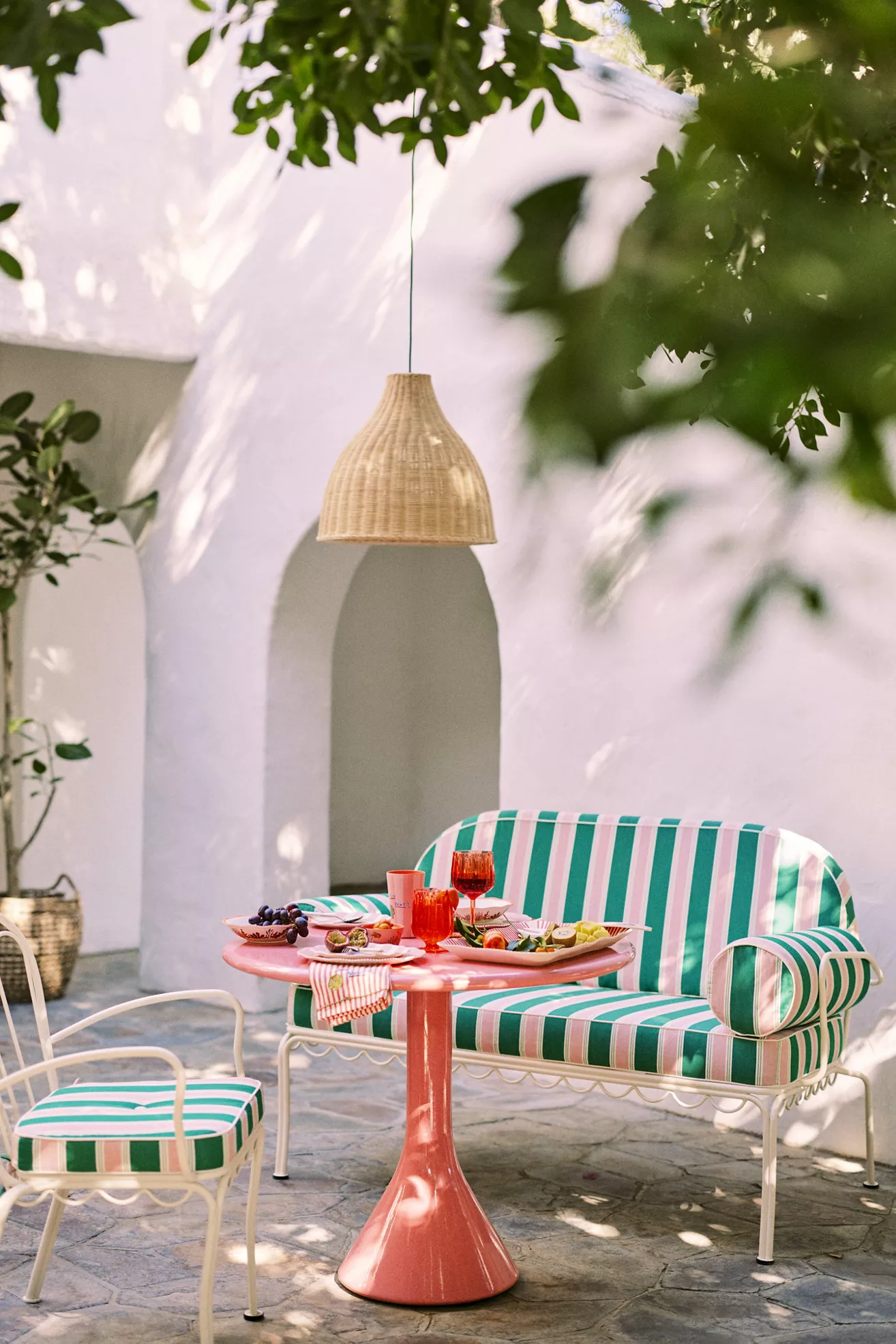 striped loveseat with table setting in courtyard