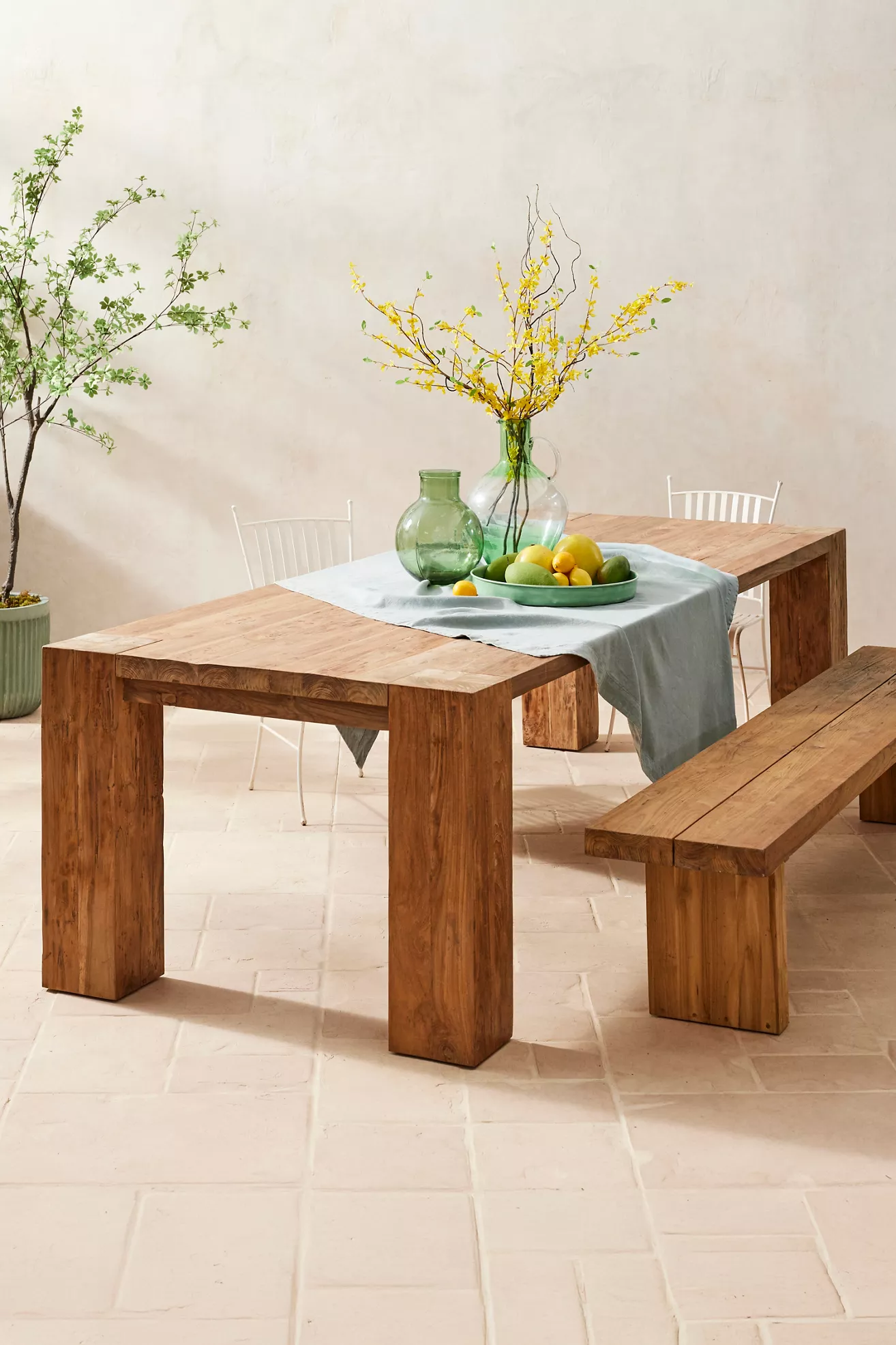 Wood dining table with bench and fruit centerpiece