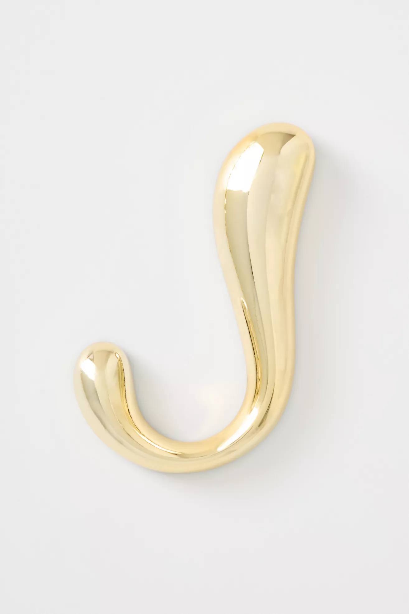 Gold decorative letter 'J' with a wavy design on a plain background.