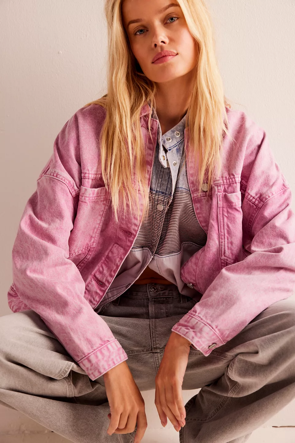 A woman wearing a pink denim jacket