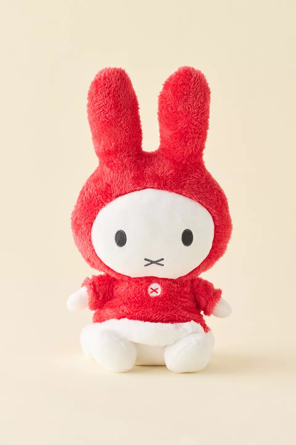 A white rabbit plushie wearing a red winter coat and hood
