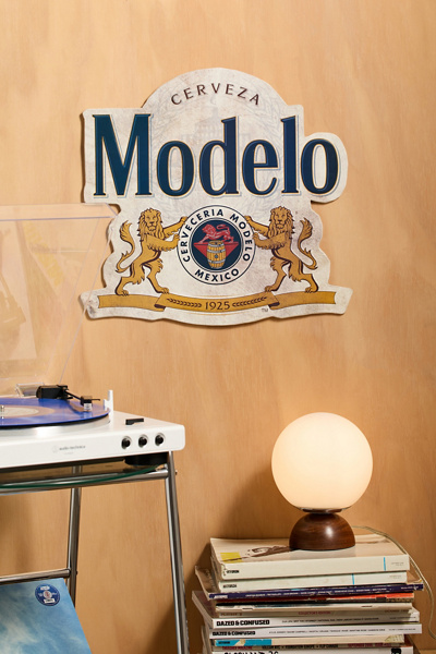 Modelo Logo Shaped Embossed Metal Wall Sign | Urban Outfitters