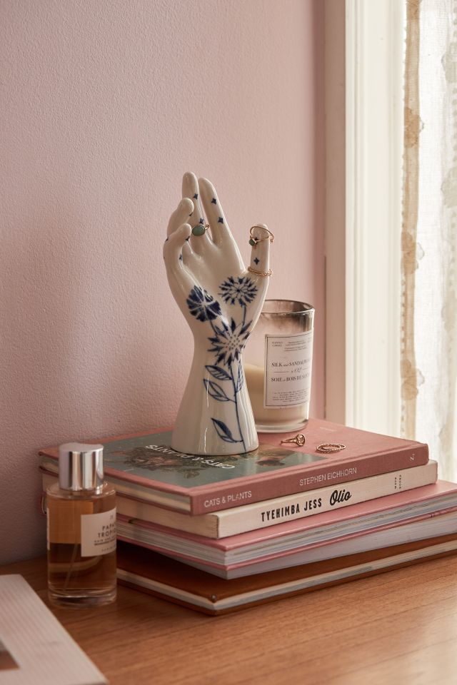 hand-shaped porcelain ring holder with intricate blue flowers painted on 