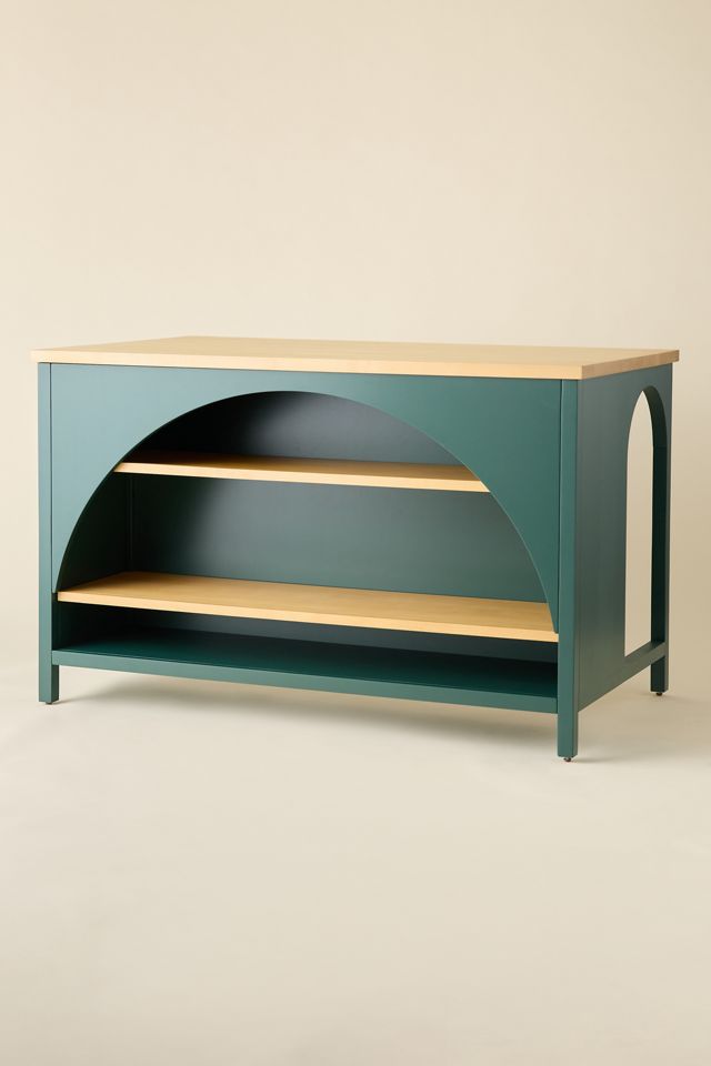 Side/front view of teal kitchen island with shelves and arch opening