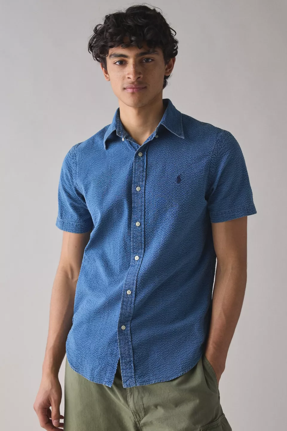 A man wearing a blue button-down collared shirt