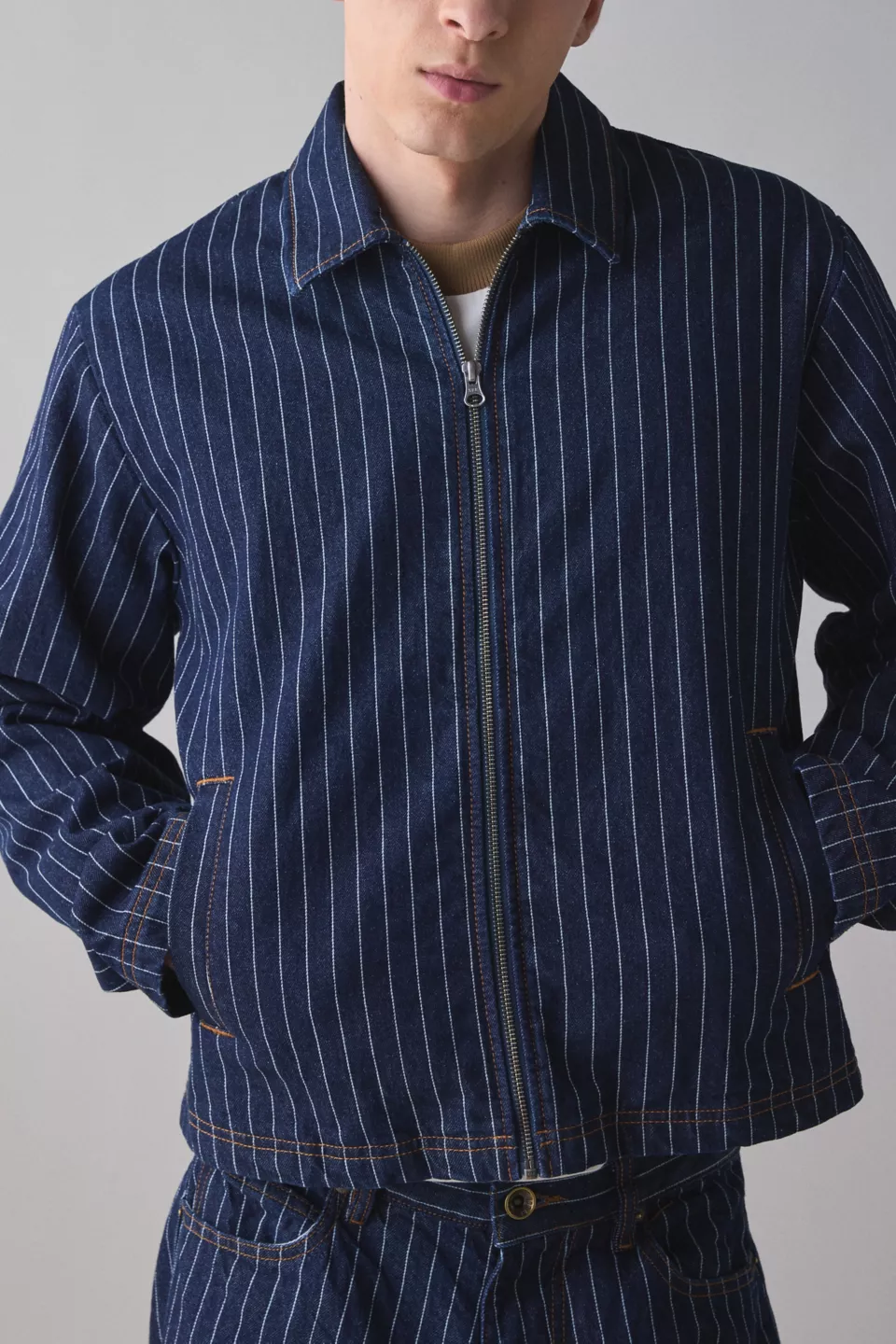 A man wearing a striped denim jacket